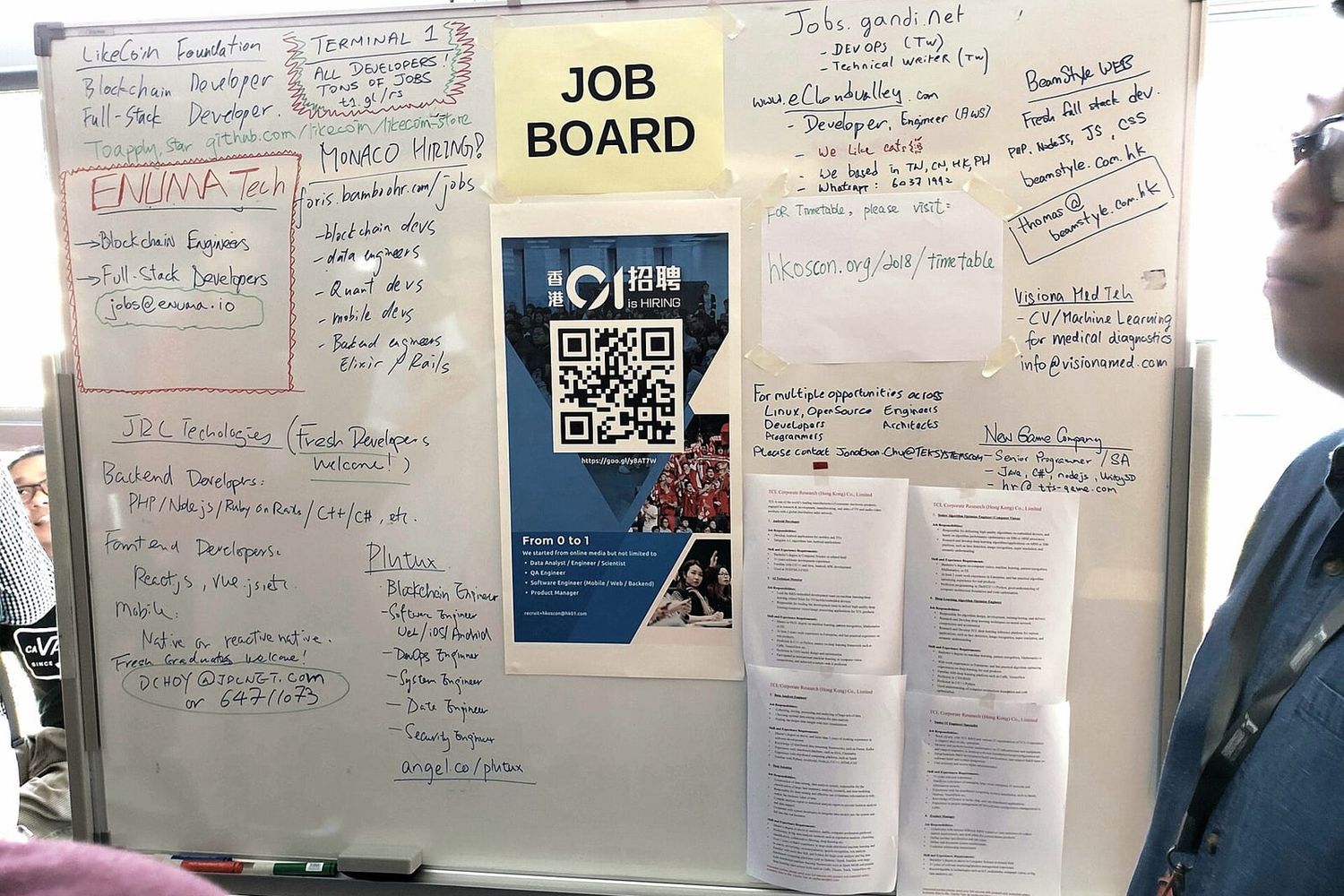 Whiteboard mit handgeschriebenen und ausgedruckten Stellenanzeigen unter einem Zettel „Job Board“